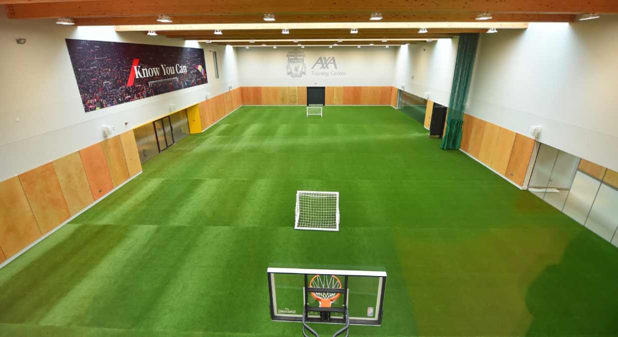 Indoor football training pitch with the AXA logo and the know you can logo on the wall